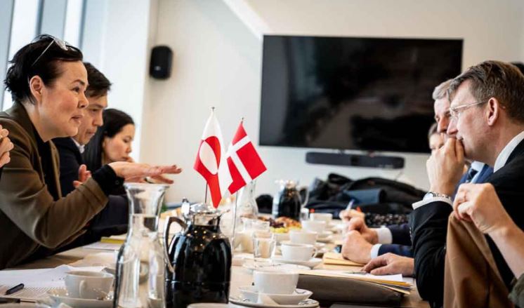 Discussion entre la ministre groenlandais de la défense, Vivian Motzfeldt, et le ministre danois de la défense, Troels Lund Poulsen, autour d'une table.