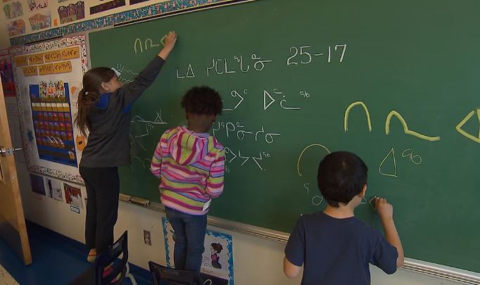 Des élèves écrivent au tableau en inuktitut.