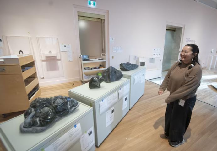 Une femme observe des sculptures dans un musée.