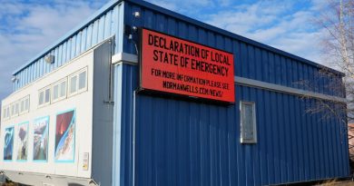 Enseigne électronique sur un bâtiment sur laquelle est affiché, en anglais : Declaration of local state of emergency.