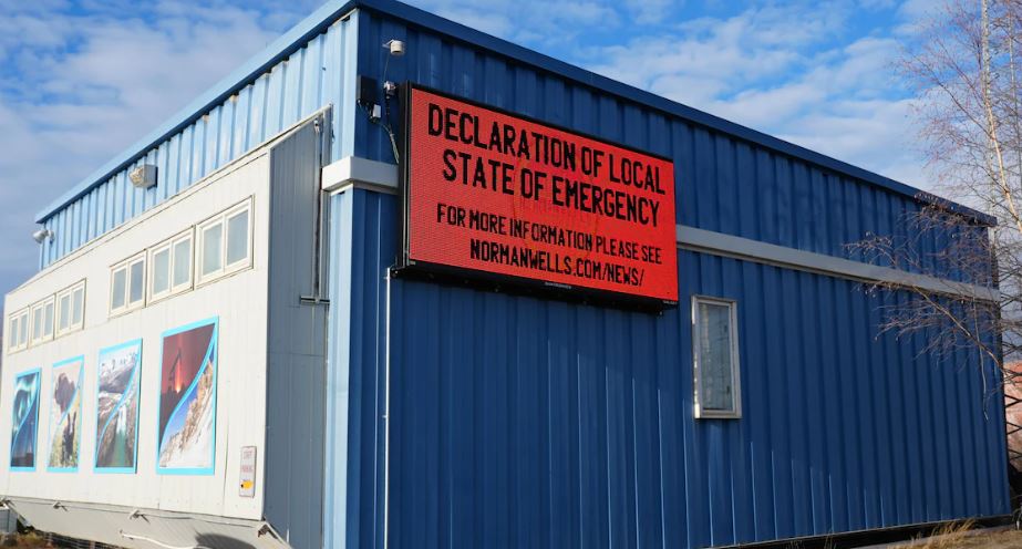 Enseigne électronique sur un bâtiment sur laquelle est affiché, en anglais : Declaration of local state of emergency.