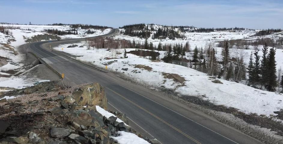 Route bordée de neige, en hiver, aux Territories du Nord-Ouest.