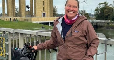 Une femme tenant son vélo.