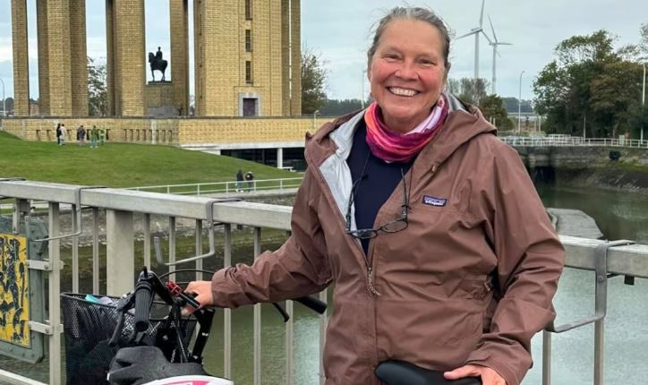 Une femme tenant son vélo.
