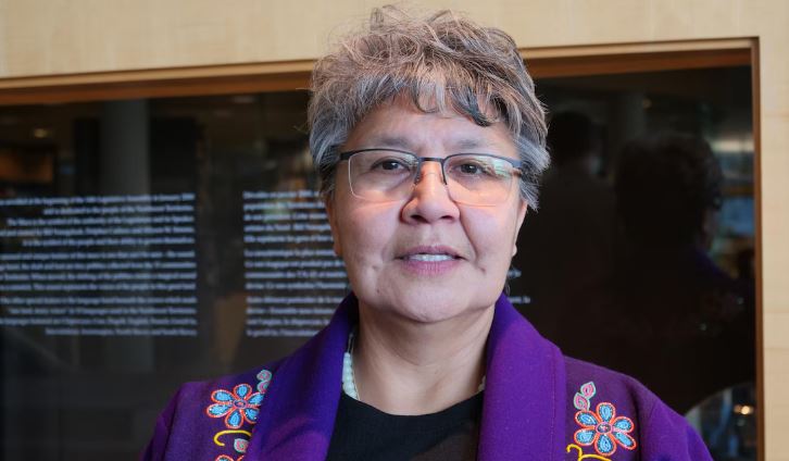 Personne aux cheveux courts, avec lunettes et veste brodée de fleurs en perles, le 24 novembre 2023, à Yellowknife.