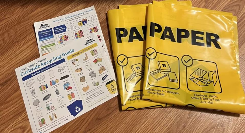 Deux bacs de recyclage bleus avec les sacs jaunes et les directives.