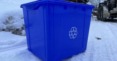 Un bac de recyclage bleu dans la neige.