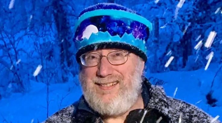 Rick Thoman tient une pelle dehors dans la neige, à Fairbanks en 2024.