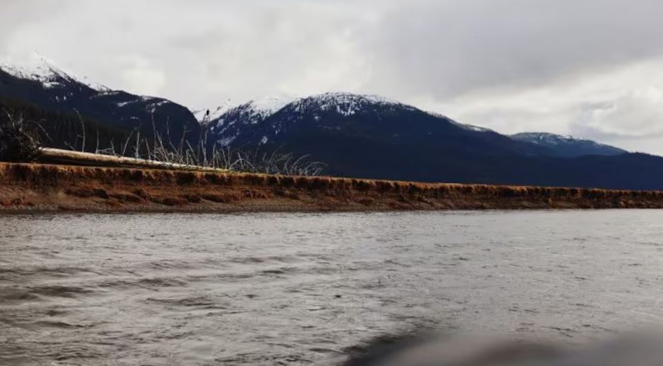 Une rivière avec des montagnes en arrière-plan.