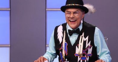 Earl Wood sur un plateau de télévision portant une veste traditionnelle arborant des bâtons de hockey.