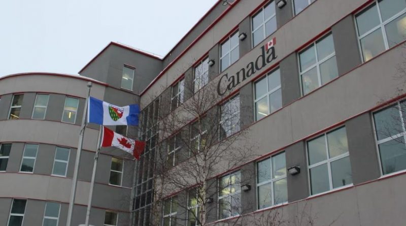 Édifice devant lequel flotte le drapeau des Territoires du Nord-Ouest et le drapeau du Canada, et sur lequel est écrit Canada, le 17 janvier 2025, à Yellowknife.