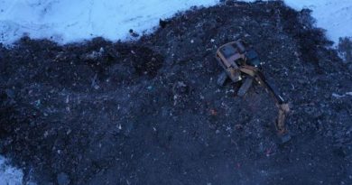 Vue aérienne sur un engin de chantier qui creuse la terre brûlée.