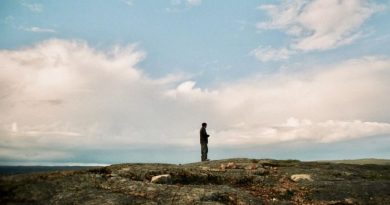 Un homme regarde à l'horizon, dans la toundra.