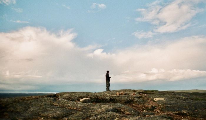 Un homme regarde à l'horizon, dans la toundra.