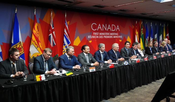 Les premiers ministres assis alignés sur une grande table. 