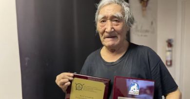 Un homme tient dans ses deux mains des documents en guise de distinction.