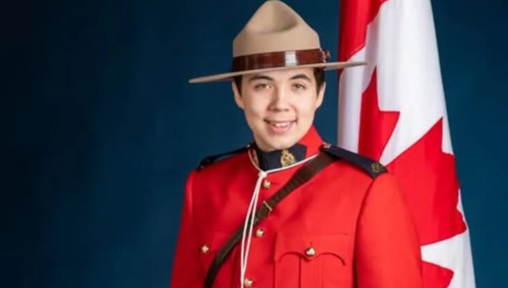 Inuuki Burke en uniforme, devant le drapeau canadien.