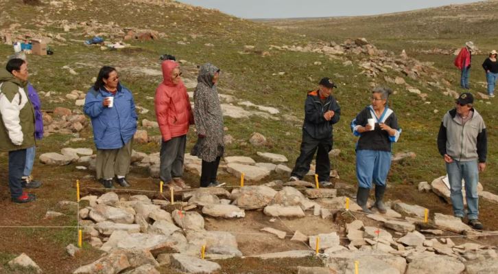 Des aînés visitent le site de Pembroke, près de Cambridge Bay, en 2008, où des chercheurs fouillent des huttes de terre.