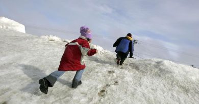 Deux enfants escaladent une montagne de neige à Browerville, en Alaska, le 7 juin 2006.
