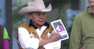 Un homme portant un large chapeau sur la tête et tenant une photo dans une main.