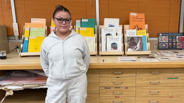 Kiana Blake devant un bureau avec des livres et des prospectus.