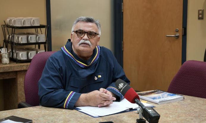 Un homme est assis devant un micro et répond à des questions de journalistes lors d'un huit clos budgétaire l’Assemblée législative du Nunavut, à Iqaluit, le 24 février 2025.