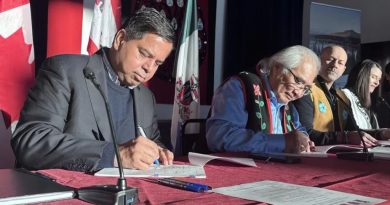 Les quatre ministres assis à une longue table en train de signer l'accord.