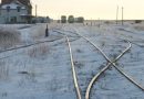 Des chemins de fer entourés de neige et des wagons au loin dans la ville de Churchill au Manitoba