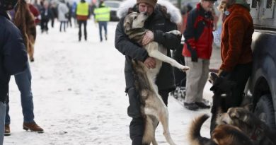 Riley Dyche serre son chien de traîneau Redoubt dans ses bras.