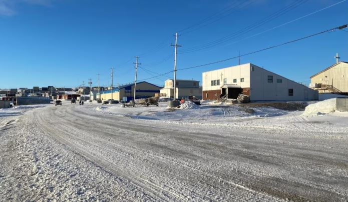 Une rue enneigée bordée de bâtiments et de maisons.