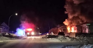 Un camion de pompier arrive près de la maison en feu.