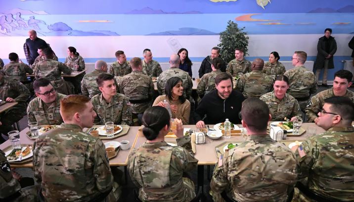 M. Vance et sa femme prennent leur repas tout en discutant attablés avec des militaires américains.