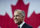 Mark Carney sourit sur une scène devant un immense drapeau canadien.
