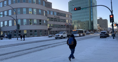 Un piéton traverse une rue enneigée au centre-ville de Yellowknife