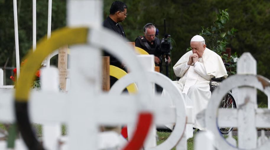Le pape se recueille devant les tombes d'un cimetière.