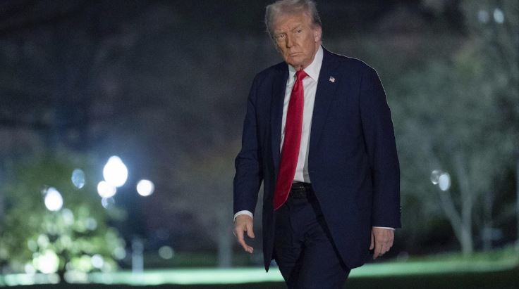 Donald Trump marche dans la pénombre à l'extérieur.