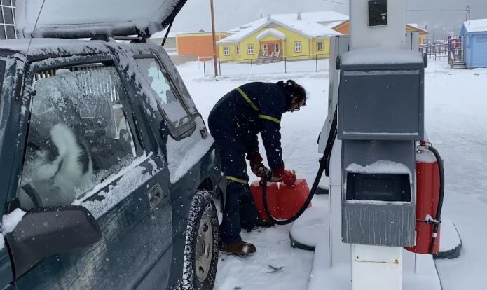 Un homme remplit une citerne d'essence à la pompe en hiver, le 1er avril 2025.