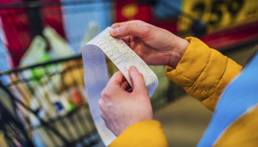 Une personne vérifie sa facture d'épicerie.