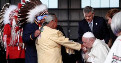 Le pape embrasse la main d'une femme.