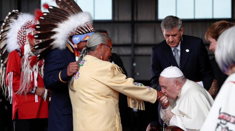 Le pape embrasse la main d'une femme.