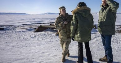 Une femme en uniforme discute avec la femme de J.D. Vance pendant que ce dernier regarde au loin les paysages enneigés.