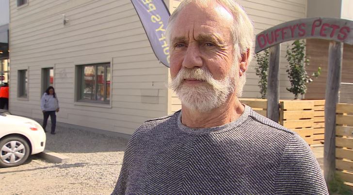 Un homme devant un magasin d'animaux de compagnie.