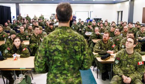 Des militaires assis à des bureaux écoutent une présentation le 2 mars 2025.