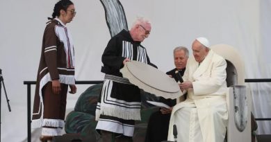 Deux personnes en costume traditionnel inuit présentent un tambour au pape François.