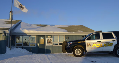Un poste de police, devant lequel un véhicule de police est stationné.