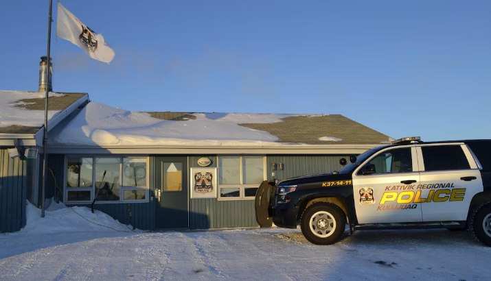 Un poste de police, devant lequel un véhicule de police est stationné.