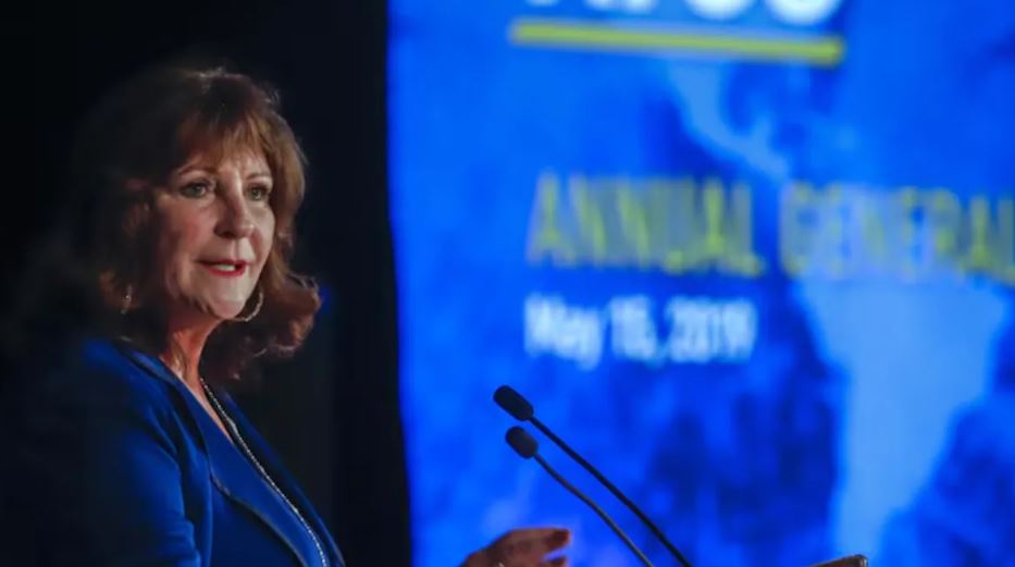 Nancy Southern parle devant un podium. 