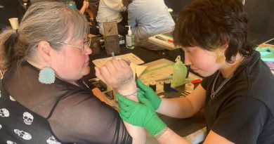 Une artiste autochtone applique un tatouage traditionnel à la main sur l’avant-bras d’une participante, lors d’un rassemblement culturel à Whitehorse.