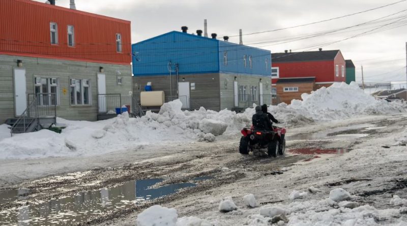 Une rue enneigée sur laquelle circule un VTT à quatre roues.