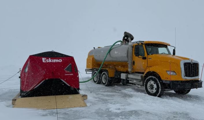 Un camion-citerne pompe de l'eau à même la station de pompage, près de Puvirnituq, au Nunavik.
